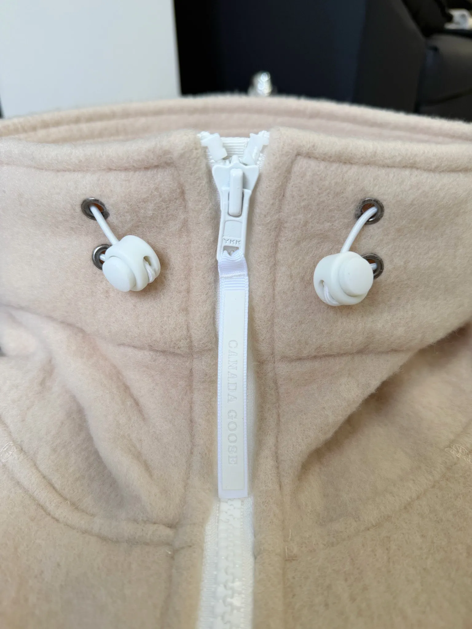 P660 Canada Goose Fleece Wool Badge Hooded Jacket Fabric selection: Wool fleece fabric blended with wool as the main body and a very small amount of spandex and polyester fiber. Wool is a core natural ingredient that provides unparalleled temperature regulation, antibacterial and anti-odor properties and a skin-friendly feel. The feeding of a small amount of spandex gives the fabric a certain degree of four-way elasticity, making it non-restrictive during daily activities. As the basis of fleece's structure, polyester fiber enhances the fabric's durability, wrinkle resistance and quick-drying properties. It contributes to the loft of the fleece and provides functions such as trapping air.  Detail 1: The sleeves and hem are closed with 2×2 ribbing. Its strong elasticity can closely fit wrists and waists of different thicknesses, forming an effective 'seal' to prevent cold wind from blowing back. It can still maintain its original shape after repeated stretching and use, and is not easy to loose and deform. And the ribbed cuffs can convey a sense of design and enhance the visual beauty.  Detail 2: The combination of hood design and elastic buckle improves warmth and windproof performance when wearing. Accessories: Customized elastic drawstring, elastic buckle, custom zipper pendant, custom armband Size: S M L Color: black gray coffee rice pink